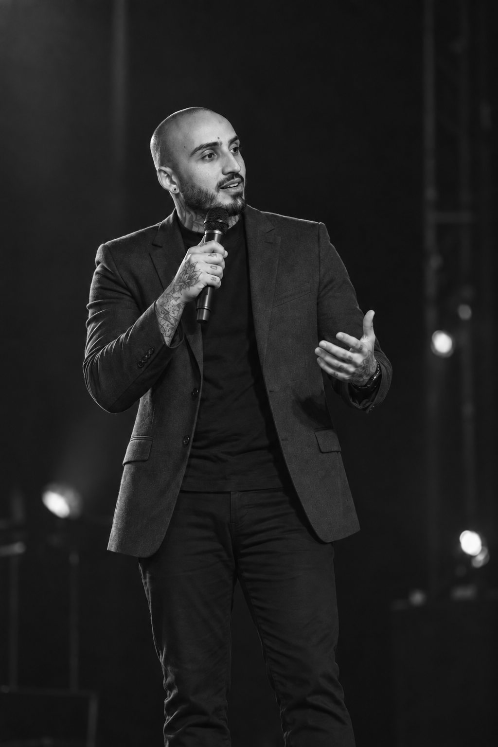 Fillipe Carvalho no palco, de microfone na mão, falando ao público